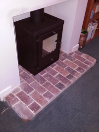 Grey Metal cube stove on Brick hearth